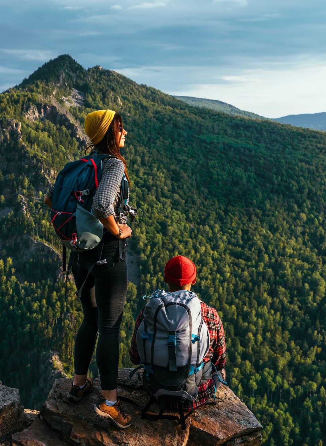 A man and a woman with backpacks on the mountain admire the panoramic view. Hiking